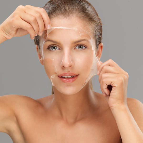 Young woman taking off peeling mask young woman peeling off a facial mask