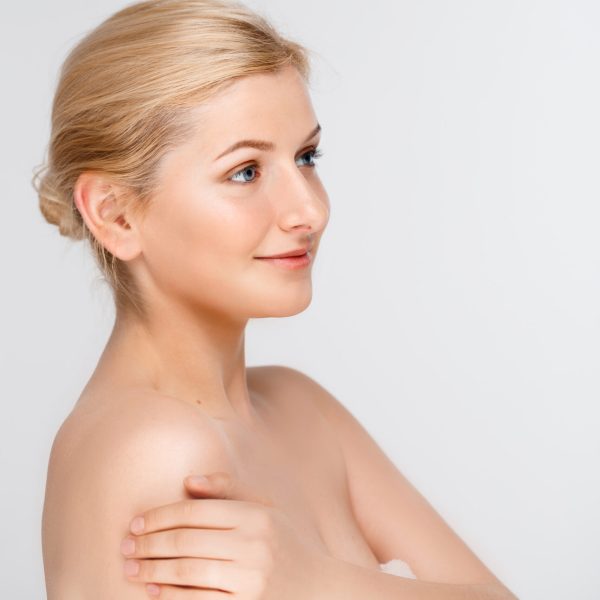 Portrait of blonde young pretty girl in towel, smiling, over white background.